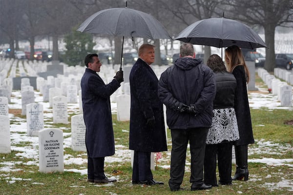 Donald Trump (second from left) and Melania Trump (right) talk with a family at Arlington National Cemetery in Virginia on Sunday.