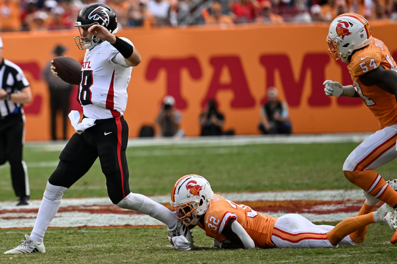 Atlanta Falcons quarterback Kirk Cousins (18) runs against Tampa Bay Buccaneers safety Josh Hayes (32) during the second half of an NFL football game, Sunday, Oct. 27, 2024, in Tampa. The Atlanta Falcons won 31-26. (AP Photo/Jason Behnken)