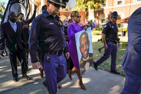 Wanda Cooper-Jones, the mother of Ahmaud Arbery, carries a portrait of her son after exiting the Glynn County Courthouse in Brunswick, Ga., Nov. 23, 2021. The judge has concluded his instructions, and jurors will now begin deciding the fate of the three men accused of murdering Arbery. (Nicole Craine/The New York Times)