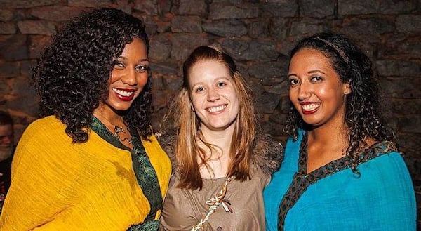 Ladies dressed in time period outfits pose for a picture.