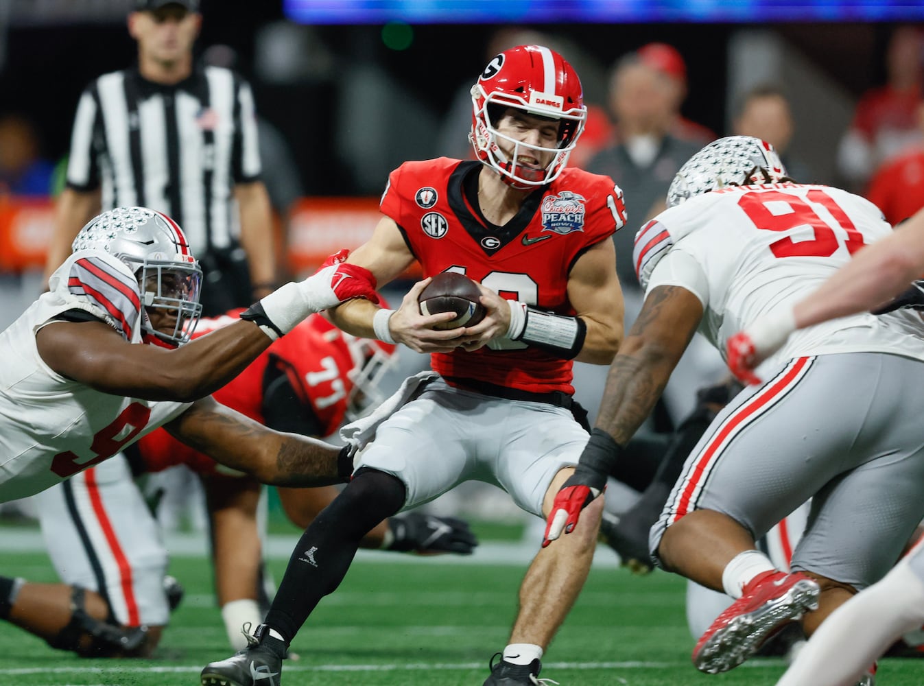 Georgia Bulldogs quarterback Stetson Bennett (13) is sacked for a loss during the third quarter. (Jason Getz / Jason.Getz@ajc.com)