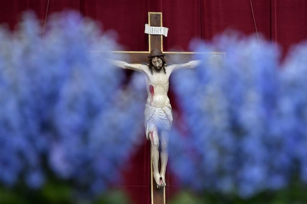 A crucifix is seen through flowers adorning St Peter's square before the Easter Sunday mass on April 16, 2017 in Vatican. Christians around the world are marking the Holy Week, commemorating the crucifixion of Jesus Christ, leading up to his resurrection on Easter. / AFP PHOTO / Tiziana FABI        (Photo credit should read TIZIANA FABI/AFP/Getty Images)