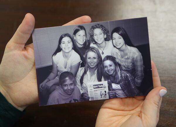 During an interview on Jan. 4, 2017, Girl Talk founder Haley Kilpatrick holds a 2002 photograph of the first Girl Talk chapter meeting that happened at the Deerfield-Windsor Middle School in Albany. (At bottom right are Kilpatrick and her sister, Kelly.) CURTIS COMPTON / CCOMPTON@AJC.COM