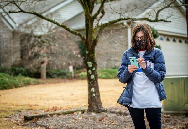 Claudia Eisenburg checks the address for her next house while canvassing a Fayetteville neighborhood on Dec. 14, 2020. (Steve Schaefer for The Atlanta Journal-Constitution) 