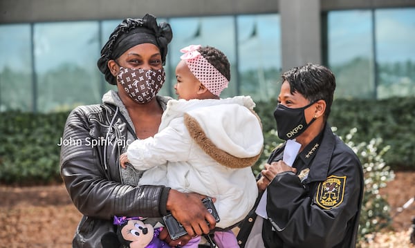 Elizabeth Grisby (left) stands with 1-year-old Royalty and DeKalb County police Chief Mirtha Ramos.