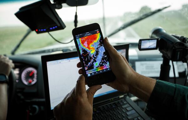 FILE PHOTO: Support scientist Tim Marshall, a 40 year veteran of storm chasing, looks at radar on his smartphone as the group tracks a supercell thunderstorm.