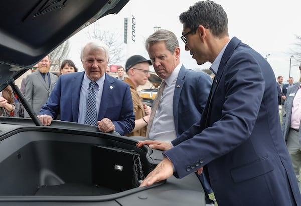 From left, Georgia Speaker of the House Jon Burns, Gov. Brian Kemp, and Rivian CEO RJ Scaringe look inside the trunk of a Rivian electric vehicle following a news conference celebrating the first-ever Rivian Day at the Georgia State Capitol on March 1, 2023. (Natrice Miller/The Atlanta Journal-Constitution/TNS)