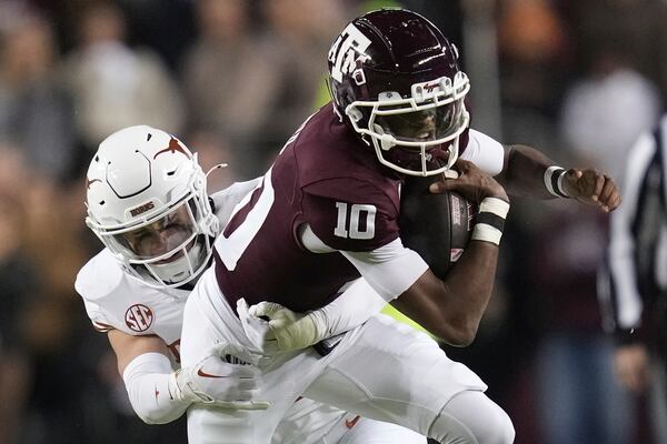 Texas A&M quarterback Marcel Reed (10) is tackled after a short gain by Texas defensive back Michael Taaffe, left, during the first quarter of an NCAA college football game Saturday, Nov. 30, 2024, in College Station, Texas. (AP Photo/Sam Craft)