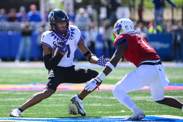 TCU wide receiver Quentin Johnston (1) dodges Kansas safety Kenny Logan Jr. (1) during the second half of an NCAA college football game Saturday, Oct. 8, 2022, in Lawrence, Kan. (AP Photo/Reed Hoffmann)