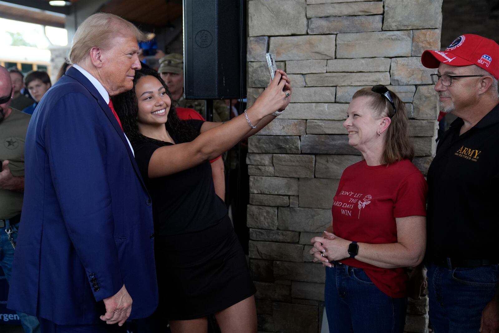 Republican presidential nominee former President Donald Trump greets people at a temporary relief shelter as he visits areas impacted by Hurricane Helene, Friday, Oct. 4, 2024, in Evans, Ga. (AP Photo/Evan Vucci)