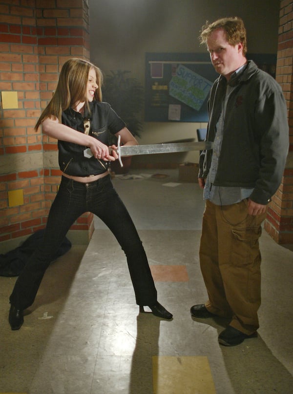 FILE - Actor Michelle Trachtenberg, left, who portrays Dawn, Buffy's sister Emmy, playfully spears series producer-creator Joss Whedon, during the taping of the final episode of "Buffy the Vampire Slayer" in Santa Monica, Calif., April 16, 2003. (AP Photo/Damian Dovarganes, File)