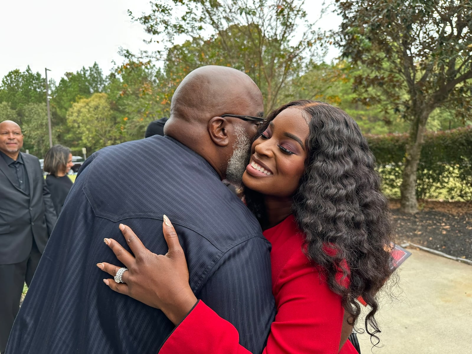 Two former V-103 hosts Griff and Shamea Morton hug after the Wanda Smith homegoing service at Word of Faith Family Worship Cathedral in Austell Nov. 4, 2024. RODNEY HO/rho@ajc.com