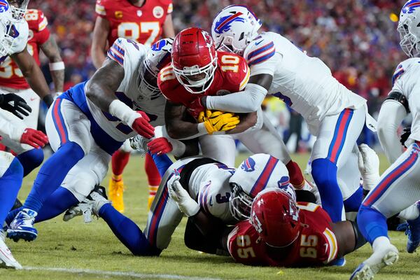 Kansas City Chiefs running back Isiah Pacheco (10) is stopped short of the end zone by Buffalo Bills defensive tackle Jordan Phillips, left, and cornerback Kaiir Elam, right, during the first half of the AFC Championship NFL football game, Sunday, Jan. 26, 2025, in Kansas City, Mo. (AP Photo/Ed Zurga)