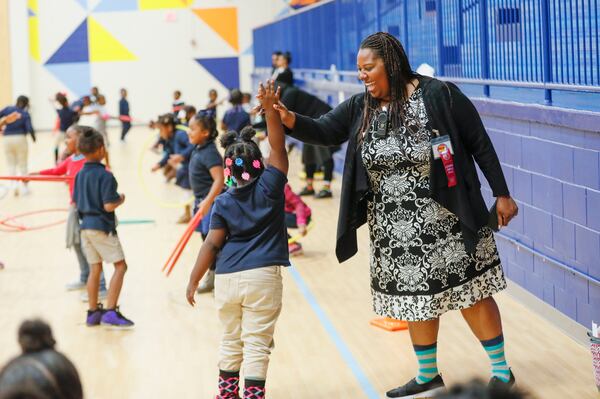 Harper-Archer Elementary School Principal Dione Simon Taylor high fives a student during the monthly "Gym Jam", an event to reward students who have earned enough points to attend.    Bob Andres / robert.andres@ajc.com