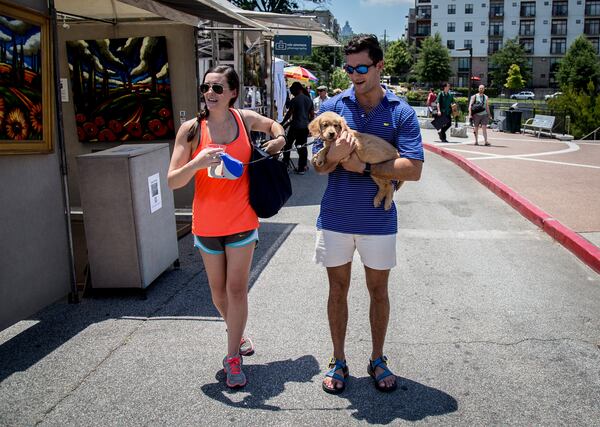 Harrison Love holds Virginia Johnson's 9-week old golden retriever puppy as they make their way through the Old Fourth Ward Park Arts Festival in Atlanta, Ga. Saturday, June 25, 2016. STEVE SCHAEFER / SPECIAL TO THE AJC