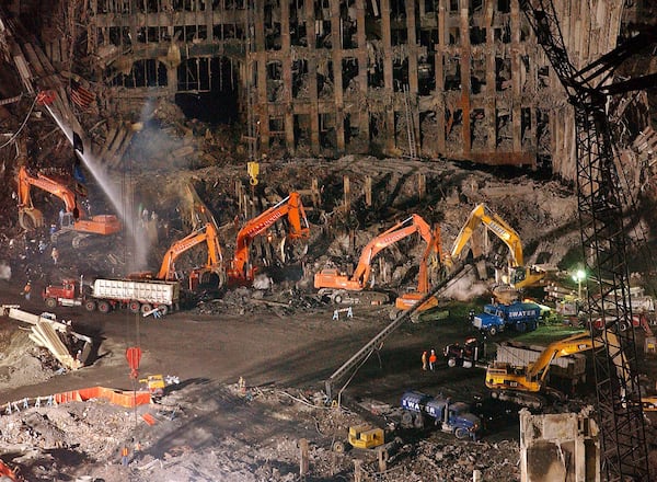 Workers and heavy machinery continue the cleanup and recovery effort in front of the remaining facade of One World Trade Center at ground zero in November 2001. The clearing of the debris took months. (File photo)