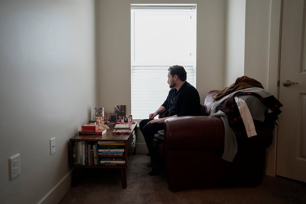 FILE - Ashton Colby looks out the window of his meditation corner in his apartment in Columbus, Ohio, on Thursday, Jan. 18, 2024. Ohio Gov. Mike DeWine announced proposals in January that transgender advocates say could block access to gender-affirming care provided by independent clinics and general practitioners, leaving thousands of adults scrambling for treatment and facing health risks. Colby, 31, fears the clinic where he gets the testosterone he has taken since age 19 would no longer offer it. (AP Photo/Carolyn Kaster, File)