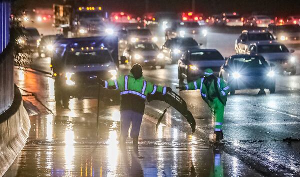 Georgia Department of Transportation workers clean drains along the Downtown Connector between University Avenue and Langford Parkway.