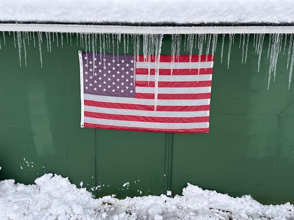 Icicles form over a flag during a snow storm, in Lowville, N.Y., on Sunday Dec, 1, 2024. (AP Photo/Cara Anna)