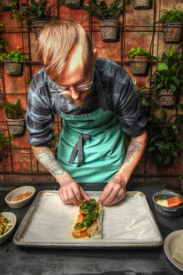 Two Urban Licks executive chef Shain Wancio folds the puff pastry around the edges of the oven components for a savory galette. (Styling by chef Shain Wancio / Chris Hunt for the AJC)