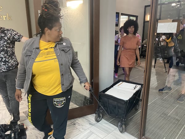 Organizers Mary Hooks, left, and Mariah Parker, right, walk out of the municipal clerk's office at Atlanta city hall with 3,000 copies of the petition referendum forms. The group will have 60 days to collect more than 70,000 signatures from registered Atlanta voters.