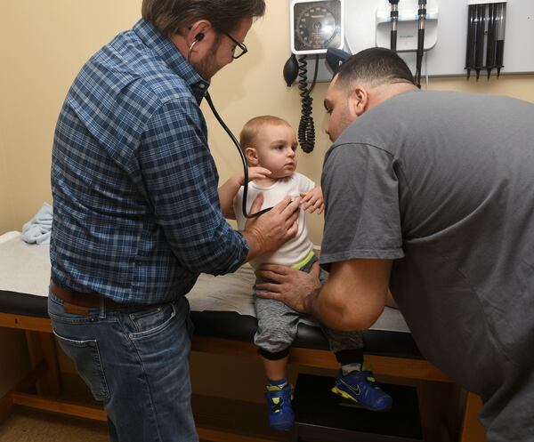 Dr. Greg McHan (left) examines Lenny Falletta III (center) at the Georgia Mountains Health clinic in Blue Ridge in Sept. 2017. (Rebecca Breyer)