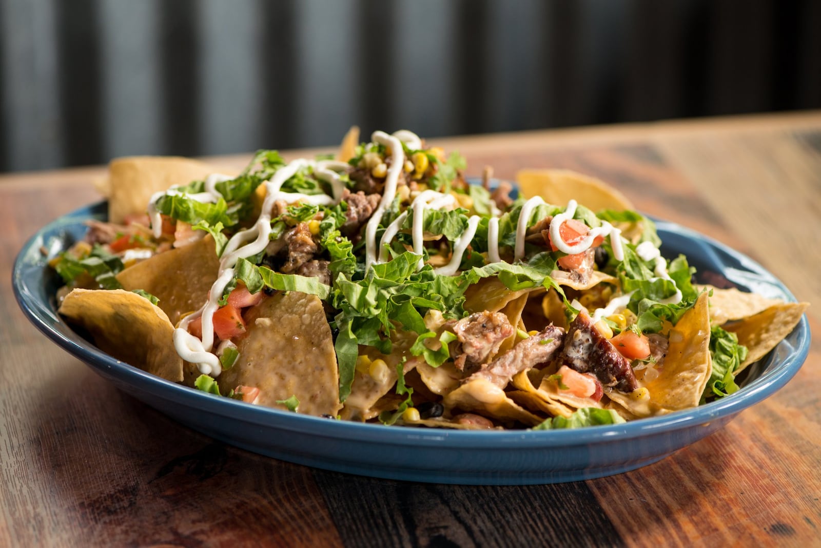  Big Tex Nachos with brisket, queso, lettuce, pico de gallo, black beans, sour cream, and roasted corn. Photo credit- Mia Yakel.