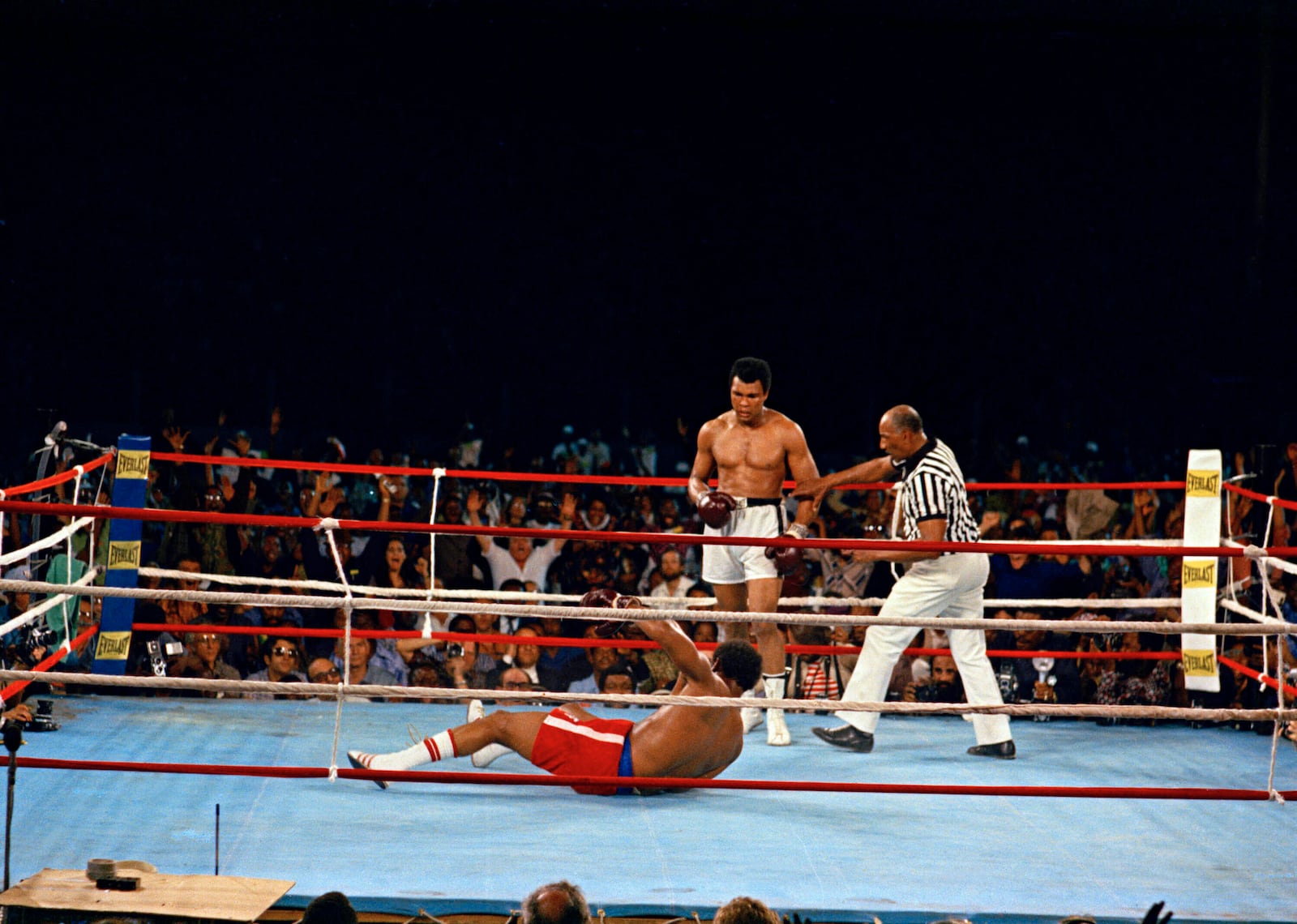 FILE - Muhammad Ali looks down at George Foreman during their bout in Kinshasa, Zaire, Oct. 30, 1974. (AP Photo, File)