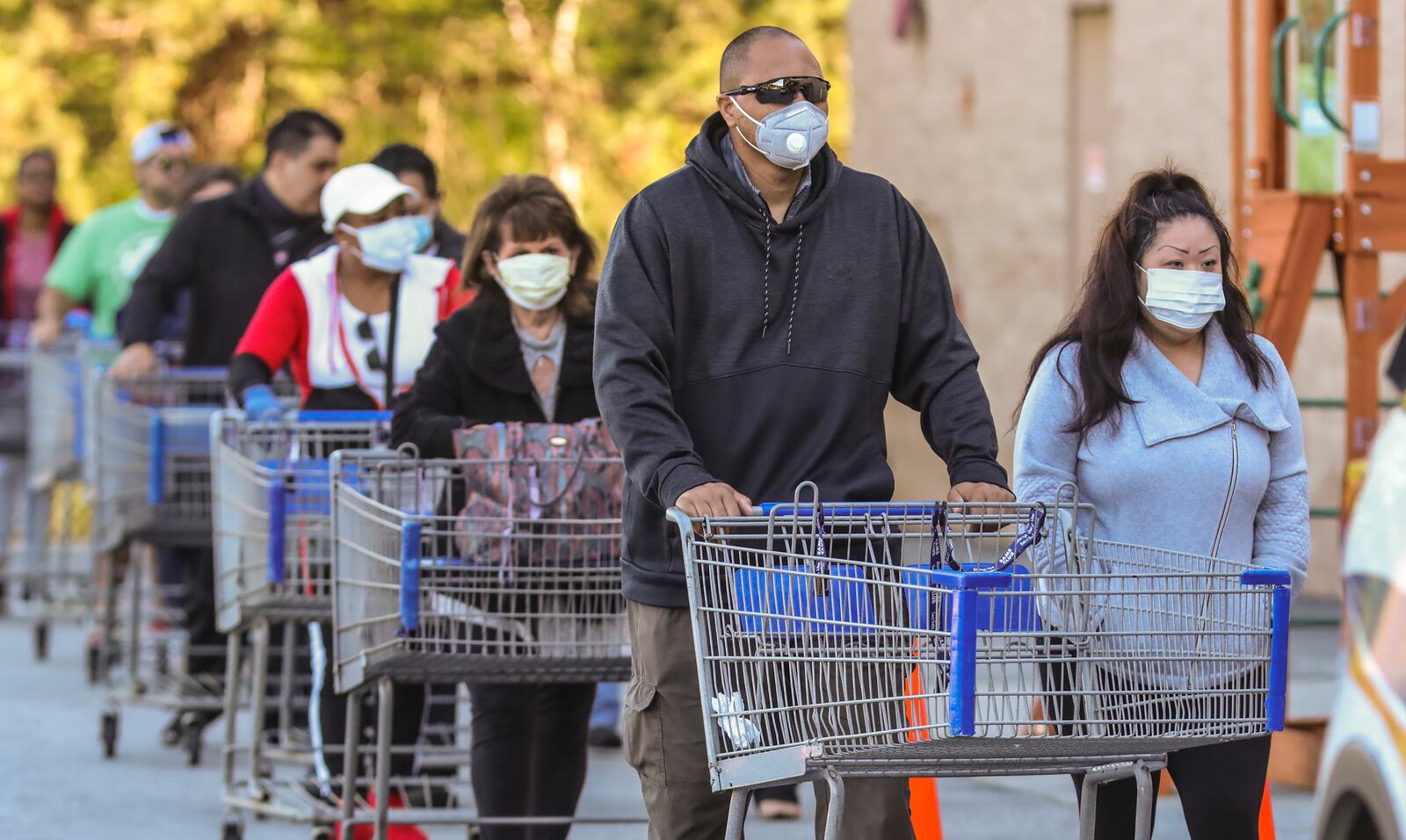 Customers lined up over the length of a football field at the Sam’s Club on Clairmont Road in DeKalb County on Friday, April 3, 2020. Chamblee police had an officer on site to monitor the crowd, which was being let into the store in lower numbers to ensure social distancing. JOHN SPINK/JSPINK@AJC.COM