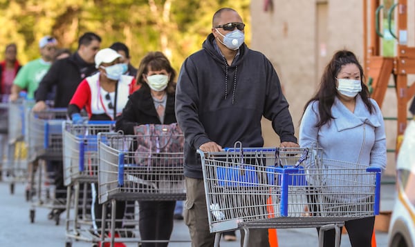 Customers lined up over the length of a football field at the Sam’s Club on Clairmont Road in DeKalb County on Friday, April 3, 2020. Chamblee police had an officer on site to monitor the crowd, which was being let into the store in lower numbers to ensure social distancing. JOHN SPINK/JSPINK@AJC.COM