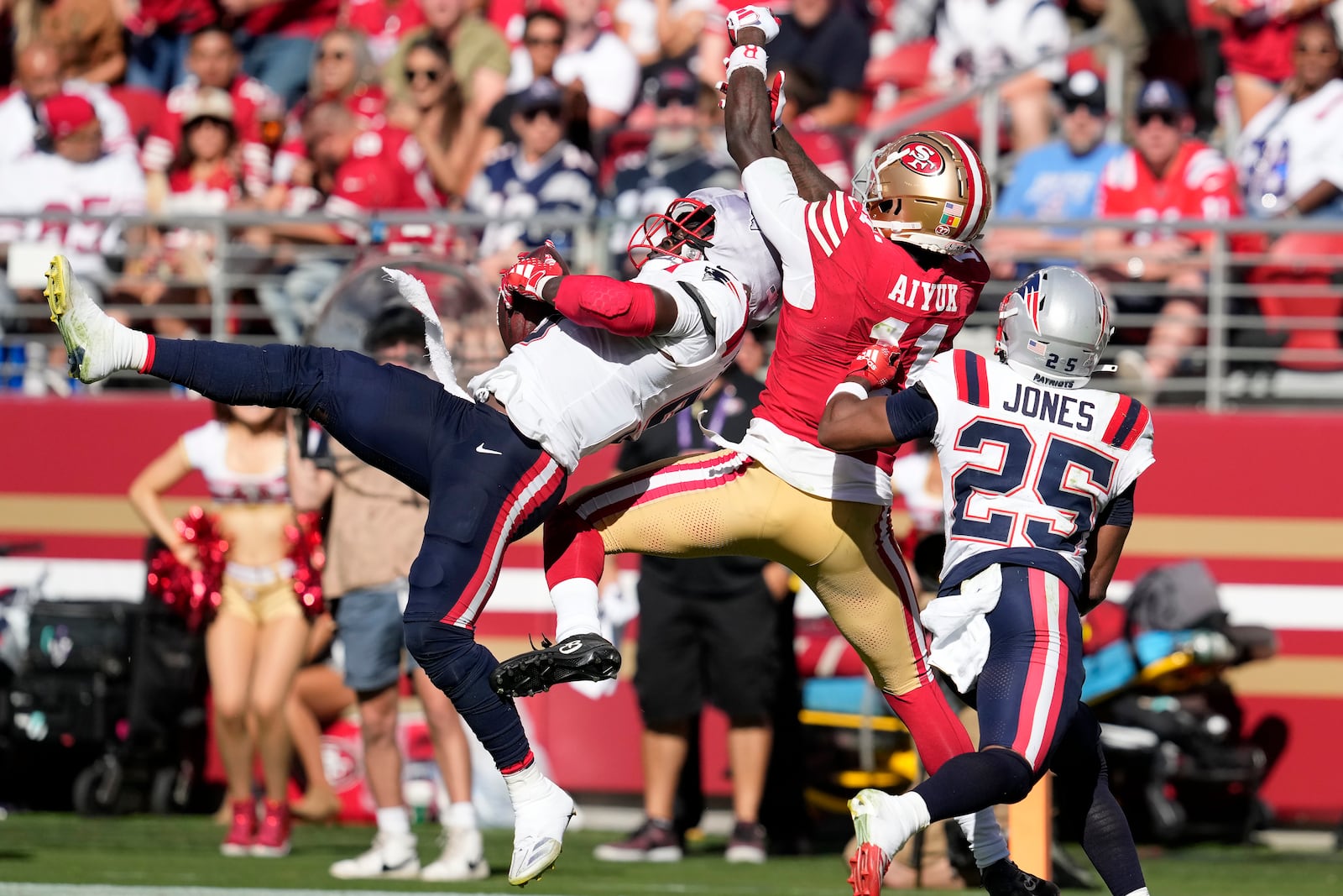 New England Patriots safety Jabrill Peppers, left, intercepts a pass intended fo San Francisco 49ers wide receiver Brandon Aiyuk, middle, as cornerback Marcus Jones (25) watches during the second half of an NFL football game in Santa Clara, Calif., Sunday, Sept. 29, 2024. (AP Photo/Godofredo A. Vásquez)