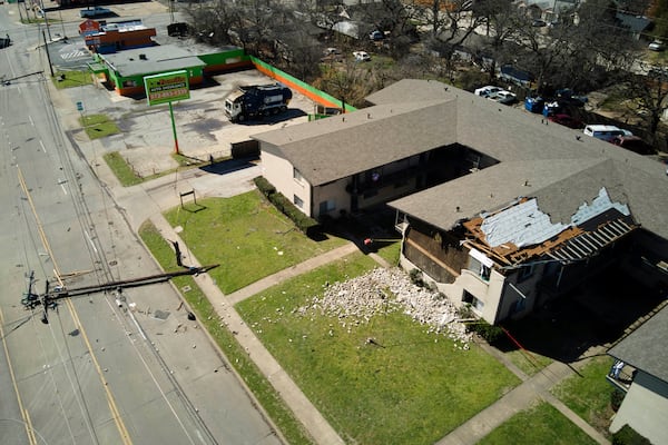 A downed power line rests on the road near an apartment building damaged during early morning storm that hit the Dallas region Tuesday, March 4, 2025, in Irving, Texas. (AP Photo/Julio Cortez)