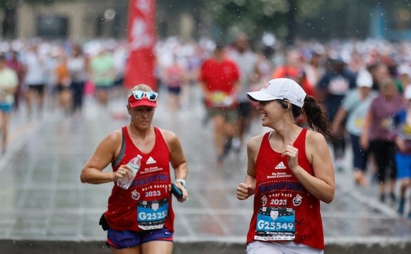 Runners endure some rain during the 54th running of the Atlanta Journal-Constitution Peachtree Road Race in Atlanta on Tuesday, July 4, 2023. The race would later end early because of the weather turning severe.  (Miguel Martinez / Miguel.Martinezjimenez@ajc.com)