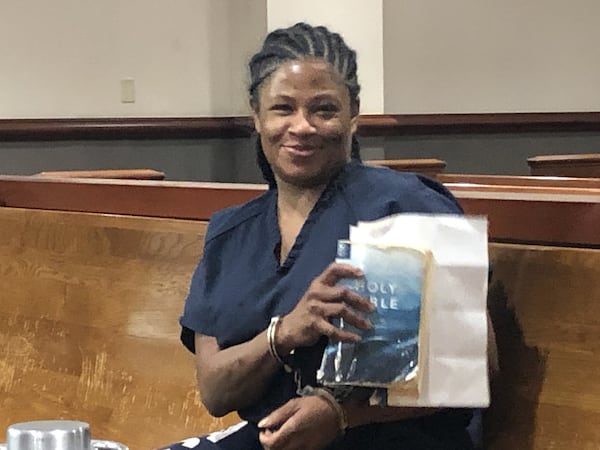 Angela Dalton sits in handcuffs while holding a Bible at her Dec. 5 court hearing in Atlanta municipal court. She said she had been reading the Bible in jail as she waits for a treatment bed to open up. WILLOUGHBY MARIANO / WMARIANO@AJC.COM