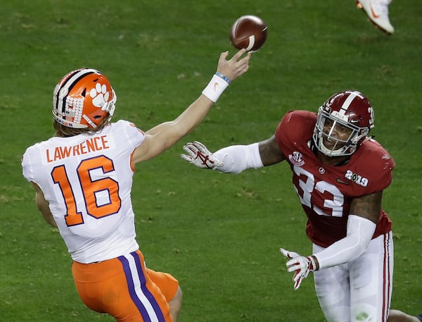 Clemson's Trevor Lawrence throws while being rushed by Alabama's Anfernee Jennings during the first half of the NCAA college football playoff championship game, Monday, Jan. 7, 2019, in Santa Clara, Calif.