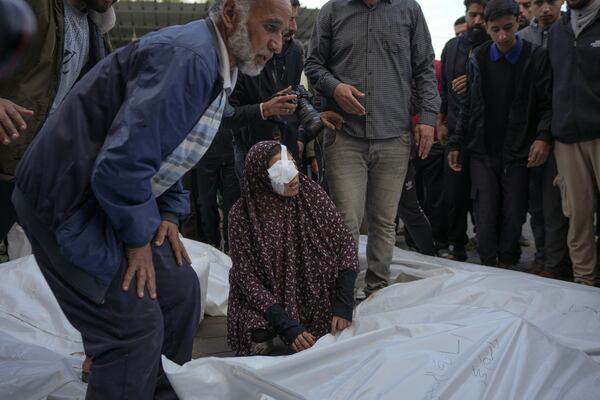 Isra Al Habash, mourns her father and brothers, victims of an Israeli army strike on the Nuseirat refugee camp, at the Al-Aqsa Martyrs hospital in Deir al-Balah, Gaza Strip, Thursday Dec. 12, 2024. Palestinian medical officials say Israeli airstrikes have killed at least 28 people in the Gaza Strip, including seven children and a woman. (AP Photo/Abdel Kareem Hana)