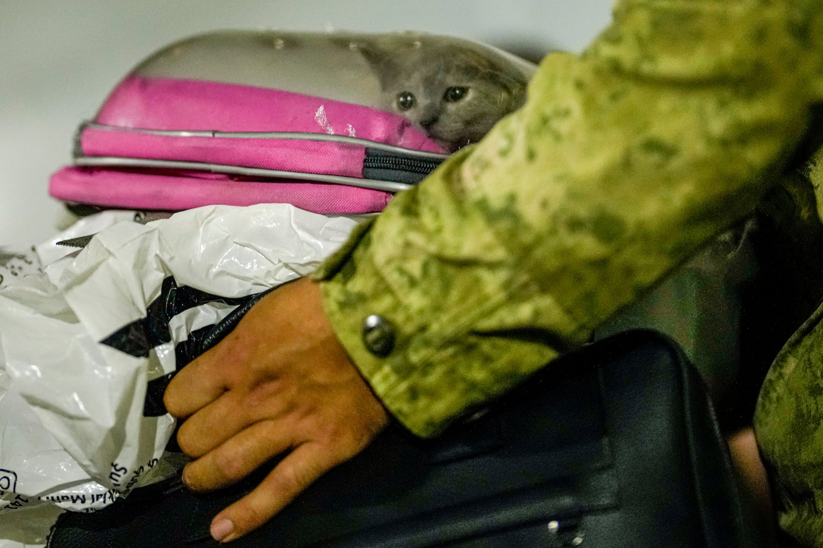 A Turkish military member carries luggages as people mostly Turkish nationals disembark from Turkish TCG Sancaktar military ship after being evacuated from Lebanon's capital Beirut to Turkey, in Mersin port, southern Turkey, early Friday, Oct. 11, 2024. (AP Photo/Emrah Gurel)