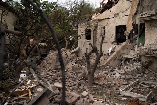 A member of the Israeli forces inspect a site following a rocket fired from Lebanon hit an area in Rinatya, outskirts of Tel Aviv, Israel, Sunday, Nov. 24, 2024. (AP Photo/Leo Correa)