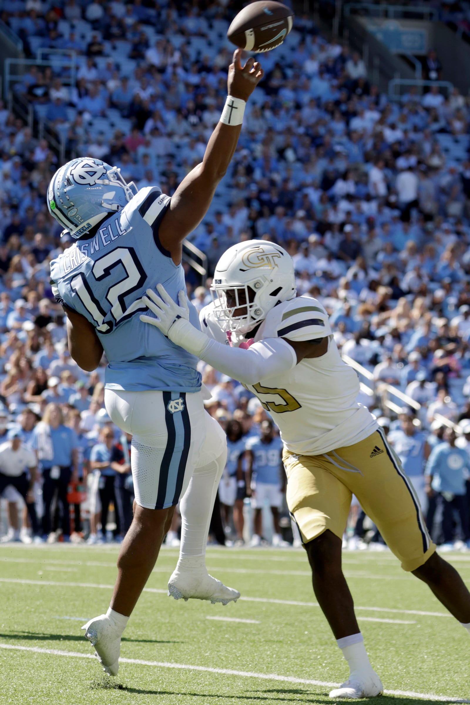 North Carolina quarterback Jacolby Criswell (12) gets off a pass as Georgia Tech linebacker Tah'j Butler (15) pressures during the first half of an NCAA college football game, Saturday, Oct. 12, 2024, in Chapel Hill, N.C. He completed the pass for a long gain. (AP Photo/Chris Seward)