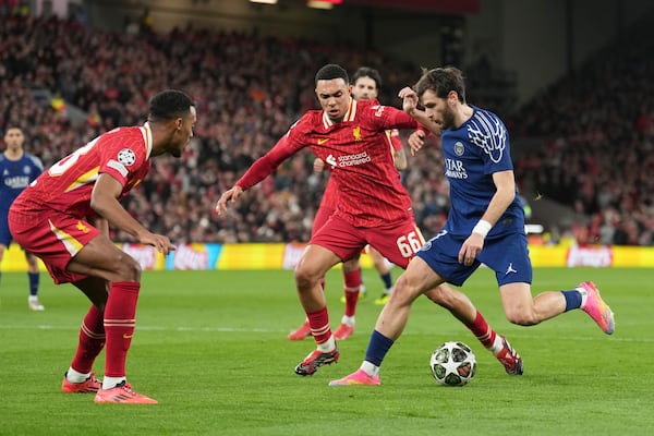 Liverpool's Trent Alexander-Arnold guards PSG's Khvicha Kvaratskhelia during the Champions League round of 16 second leg soccer match between Liverpool and Paris Saint-Germain at Anfield in Liverpool, England, Tuesday, March 11, 2025. (AP Photo/Jon Super)