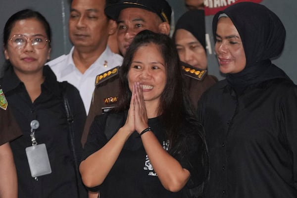 Filipino death row inmate Mary Jane Veloso, center, gestures at the media as she leaves Pondok Bambu Prison for Soekarno-Hatta International Airport in preparation for her repatriation to the Philippines, in Jakarta, Indonesia, Tuesday, Dec. 17, 2024. (AP Photo/Achmad Ibrahim)