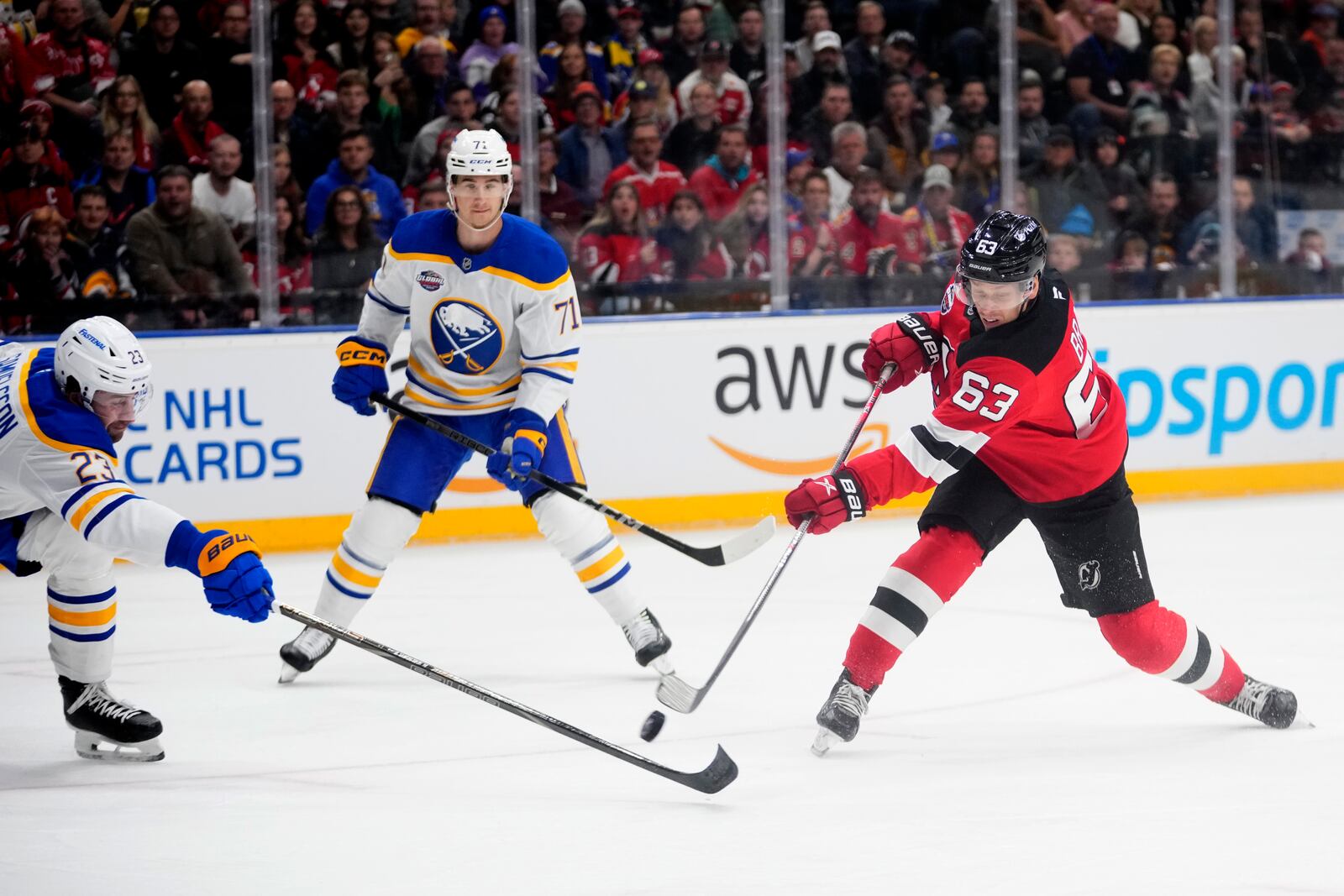 Buffalo Sabres' Mattias Samuelsson, left, trise to block a shot by New Jersey Devils' Jesper Bratt during the NHL hockey game between Buffalo Sabres and New Jersey Devils, in Prague, Czech Republic, Saturday, Oct. 5, 2024. (AP Photo/Petr David Josek)