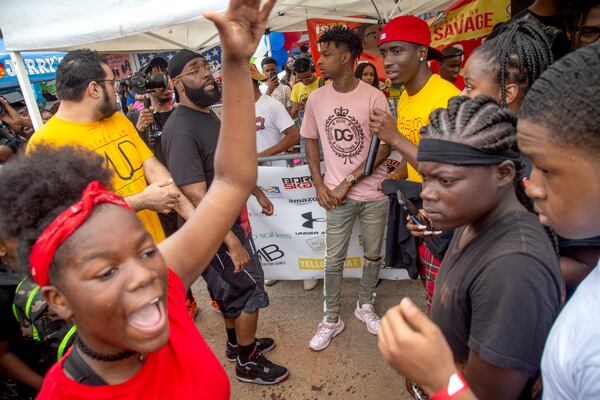 People surround 21 Savage at his annual back-to-school drive in DeKalb. STEVE SCHAEFER / SPECIAL TO THE AJC