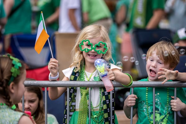 Six-year-old Eloise Tallon of Savannah waves to friends during the St. Patrick's Day parade on March 16, 2024, in Savannah, Ga. (AJC Photo/Stephen B. Morton)