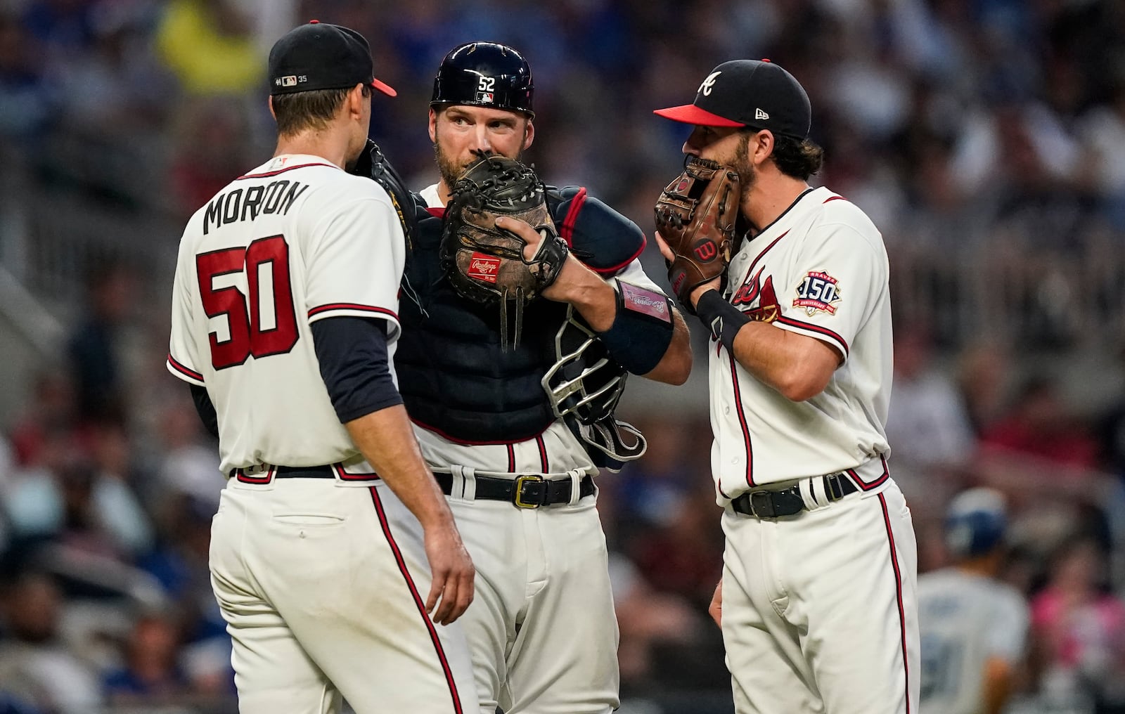 Atlanta Braves' Dansby Swanson, right, and Kevan Smith, center, meet on the mound with Charlie Morton, left, in the fourth inning of a baseball game against the Los Angeles Dodgers, Saturday, June 5, 2021, in Atlanta. (AP Photo/Brynn Anderson)