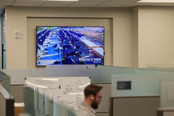 An employee with Landmark Properties works at his desk as a monitor shows recent real estate projects at their Buckhead office on March 4 in Atlanta. Landmark Properties is growing its real estate presence in Atlanta. They’re handling a high-profile student housing tower near The Varsity and have experienced two office expansions in recent years. (Jason Getz/AJC)