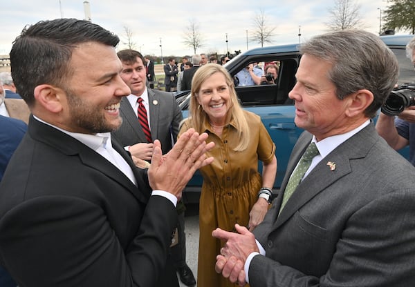 Rivian Executive Vice President of Facilities Jimmy Knauf, left, smiles as he shows a Rivian R1T electric truck to Georgia Gov. Brian Kemp and first lady Marty Kemp during a press conference at Liberty Plaza across from the Georgia Capitol in Atlanta on Dec. 16. (Hyosub Shin / Hyosub.Shin@ajc.com)