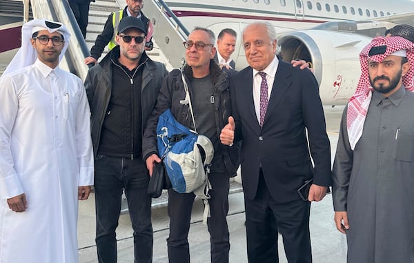 In this handout photo released by Qatar Ministry of Foreign Affairs, George Glezmann, center, poses with Qatari diplomats Adam Boehler, second left, and Zalmay Khalilzad, second right, in Kabul, Afghanistan, Thursday, March 20, 2025, before departing to Doha. (Qatar Ministry of Foreign Affairs via AP)