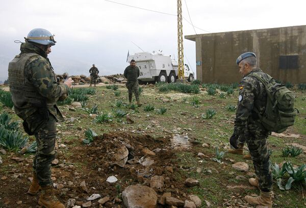 Spanish U.N. peacekeepers check the remains of Israeli army artillery shells along the Lebanese Israeli border in the southern village of Wazzani, Lebanon, Tuesday, Jan. 5, 2016. The Lebanese militant group Hezbollah struck an Israeli armored patrol with a roadside bomb at the border on Monday and Israel responded by shelling the area, with no immediate word on casualties. (AP Photo/Mohammed Zaatari)