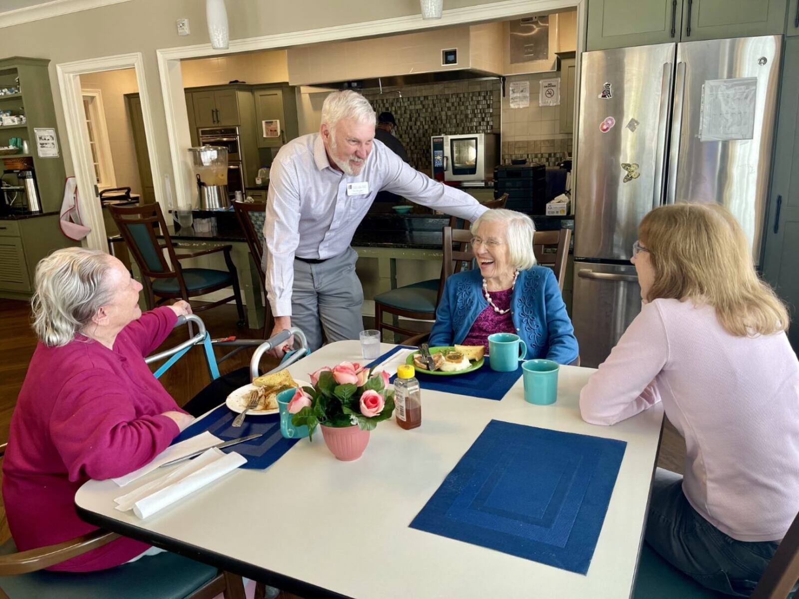 Park Springs Senior Living residents Martha Albertson, 93, left, and Geraldine Taylor, 90, second from right, converse with Taylor’s daughter, Colleen Bittinger in a Park Springs kitchen area. With them is Tim Knight, executive director of training and organizational development for Isakson Living. Isakson’s community household model of care for residents receiving health care services utilizes these areas to bring residents together for meals and socialization with each other and family.